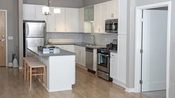 a kitchen with white cabinets and stainless steel appliances